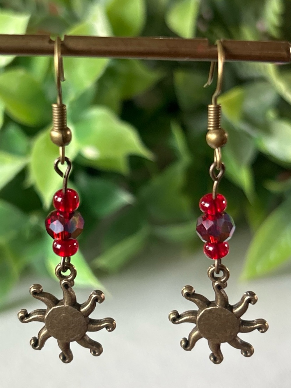 Handmade brass sun earrings with red crystal beads